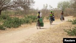 Des femmes à vélo allant dans le village de Bagare, province du Passore, nord du Burkina Faso, 30 mars, 2016. 