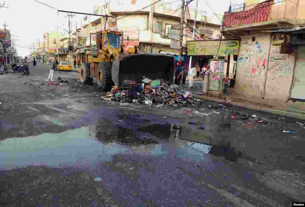 People clean a street now under militant control, in the northern city of Mosul, June 13, 2014.&nbsp; &nbsp;