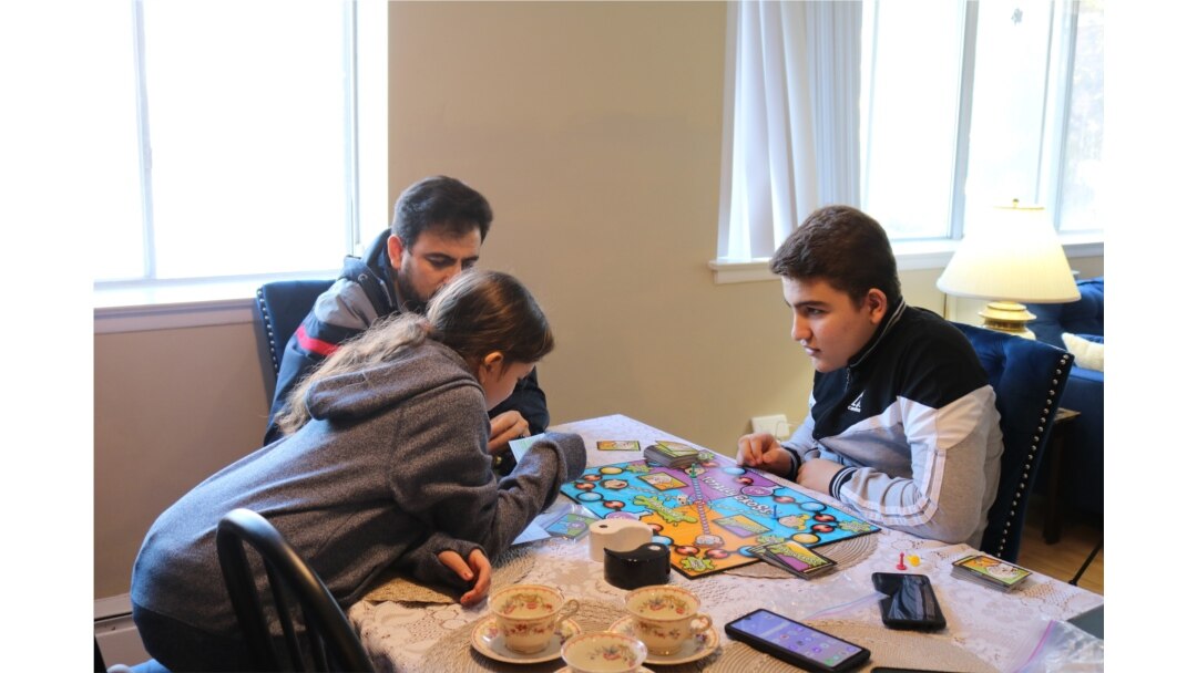 Syrian refugee Mohamed Almadani, 14, plays a game with younger sister Esraa, 10. He remembers gunfire and glass shattering in his home when the conflict in Syria escalated. (K. Khan/VOA)