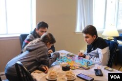 Syrian refugee Mohamed Almadani, 14, plays a game with younger sister Esraa, 10. He remembers gunfire and glass shattering in his home when the conflict in Syria escalated. (K. Khan/VOA)