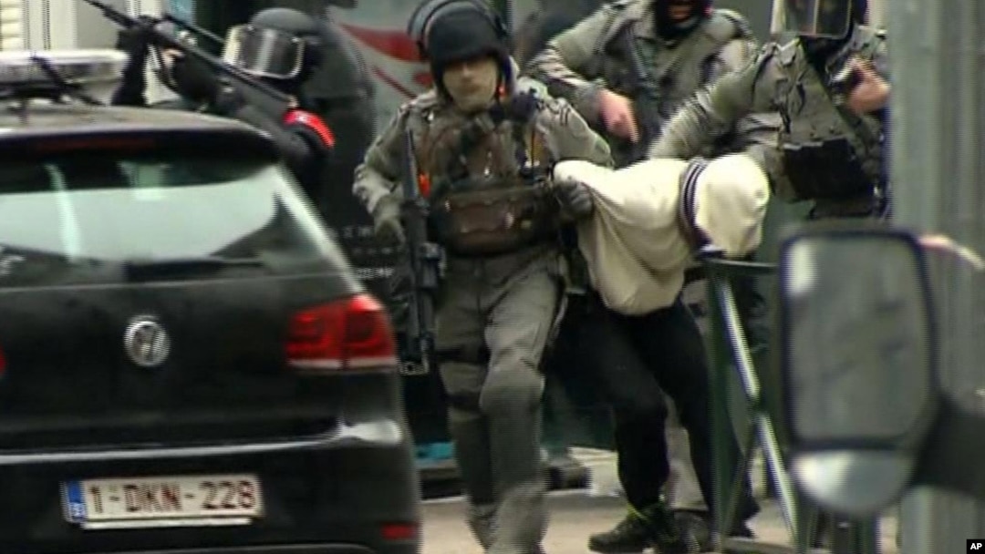 Polisi Belgia saat melakukan penggerebekan di Molenbeek, pinggiran Brussels, yang berhasil menangkap terduga teroris paling dicari di Eropa, Salah Abdeslam, Jumat (18/3). 
