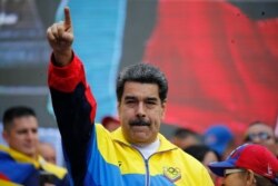 FILE - Venezuela's President Nicolas Maduro leads a rally condemning U.S. economic sanctions imposed on Venezuela, in Caracas, Aug. 10, 2019.