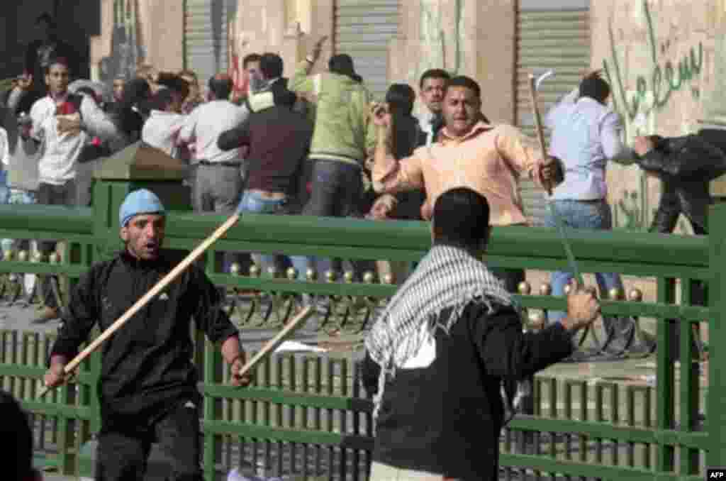 Supporters of President Hosni Mubarak fight with anti-Mubarak protesters in Cairo, Egypt, Wednesday, Feb.2, 2011. Several thousand supporters of President Hosni Mubarak, including some riding horses and camels and wielding whips, clashed with anti-governm