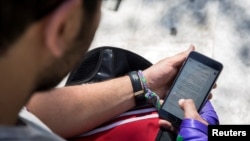 FILE - A man uses his smartphone in Tehran, Iran.