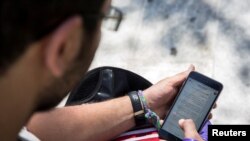 FILE - A man uses his smartphone in Tehran, Iran.