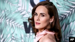 FILE - In this Feb. 24, 2017, file photo, Michelle Dockery arrives at the 10th Annual Women in Film Pre-Oscar Cocktail Party at Nightingale Plaza in Los Angeles. Filming has begun for the “Downtown Abbey” movie. Dockery, who plays Lady Mary in the global hit, posted a photo on Instagram with the caption, “And...we’re off.” 