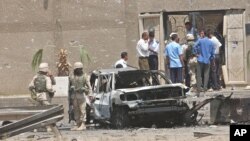  FILE - U.S. troops inspect a destroyed vehicle at the main gate of the Jordanian Embassy after a bomb attack, Aug. 7, 2003, in Baghdad, Iraq, one of the crimes for which 10 men were executed Saturday.