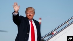 President Donald Trump melambaikan tangannya saat memasuki pesawat kepresidenan AS, Air Force One, 18 Januari 2018 di Pangkalan Angkatan Udara Andrews, Maryland. 