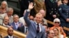 FILE - Former Olympian Chris Hoy waves as he is introduced on Centre Court ahead of the third round match between Cameron Norrie of Britain and Alexander Zverev of Germany at the Wimbledon tennis championships in London, July 6, 2024.