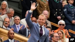 FILE - Former Olympian Chris Hoy waves as he is introduced on Centre Court ahead of the third round match between Cameron Norrie of Britain and Alexander Zverev of Germany at the Wimbledon tennis championships in London, July 6, 2024.