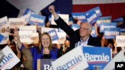 បេក្ខជន​ប្រធានាធិបតី​ខាង​គណបក្ស​ប្រជាធិបតេយ្យ លោក Bernie Sanders ដែល​ជា​សមាជិក​ព្រឹទ្ធសភា​រដ្ឋ Vermont (ស្ដាំ) និង​ភរិយា អ្នកស្រី Jane (ឆ្វេង) លើក​ដៃឡើង ខណៈ​ដែល​លោក​ឡើង​ថ្លែង​សុន្ទរកថា ក្នុង​អំឡុងពេល​ឃោសនា​បោះឆ្នោត​នៅ​ក្នុង​ទីក្រុង San Antonio ថ្ងៃសៅរ៍ ទី​២២ ខែ​កុម្ភៈ ឆ្នាំ២០២០។