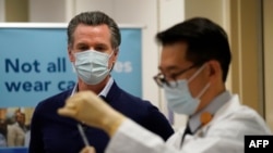 Gubernur Gavin Newsom menyaksikan vaksin Pfizer-BioNTech COVID-19 disiapkan oleh Direktur Farmasi Rawat Inap David Cheng di Kaiser Permanente Los Angeles Medical Center di Los Angeles, California pada 14 Desember 2020. (Foto: AFP)