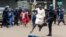 An anti-riot police man in Zimbabwe tackles a woman with his boot as they dispersed a crowd gathered to hear an address by leader of the MDC (Movement for Democratic Change) Alliance, Nelson Chamisa at Morgan Tsvangirai House, the party headquarters, in H