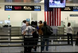 FILE - International travelers wait in line at a U.S. Customs and Border Protection checkpoint after arriving at Miami International Airport on March 4, 2015, in Miami, Florida.