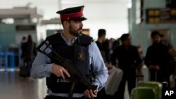 FILE - A police officer guards a terminal of the airport during tighter security measures in Barcelona, Spain. 