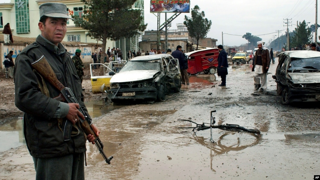 Seorang polisi Afghanistan mengamankan lokasi pasca serangan bom mobil (foto: dok). 