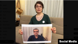 نسرین ستوده حقوقدان، عکسی از همسرش رضا خندان زندانی سیاسی را در دست دارد. 