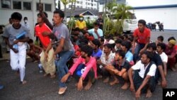 Imigran ilegal dari Myanmar dan Bangladesh tiba di kantor polisi di Langkawi, Malaysia (11/5). Pemerintah negara-negara Asia Tenggara tetap menyatakan keengganan mereka menerima para migran berperahu yang ditinggalkan para penyelundup mereka di tengah laut.