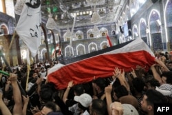 Mourners carry the body of Iraqi anti-government activist Ihab al-Wazni (Ehab al-Ouazni) during his funeral at the Imam Hussein Shrine in the central holy shrine city of Karbala on May 9, 2021.