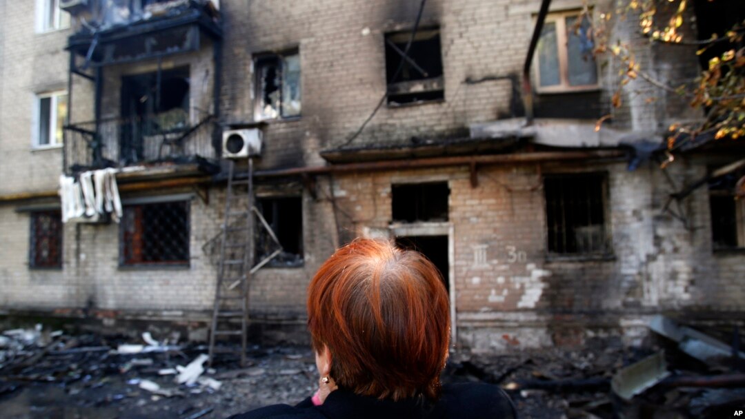 Seorang perempuan menangis di depan bangunan apartemennya yang hancur di kota Donetsk, Ukraina Timur (17/9).