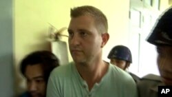 In this image made from video, Dutch citizen Klaas Haytema is escorted into a court where he was sentenced to three months in prison for interfering with a religious observance, in Mandalay, Myanmar, Oct. 6, 2016. 