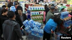 People line up to buy cartons of bottled water at a supermarket after reports on heavy levels of benzene in local tap water, in Lanzhou, Gansu province, April 11, 2014. 