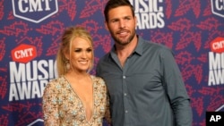 Carrie Underwood, left, and Mike Fisher arrive at the CMT Music Awards on June 5, 2019, at the Bridgestone Arena in Nashville, Tenn. 