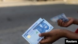 FILE PHOTO: A person holds a new 1000 Naira note as the Central Bank of Nigeria releases the notes to the public through the banks in Abuja.