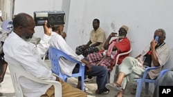 Somalis listen to news from the London conference on a radio in Mogadishu, Somalia, February 23, 2012.