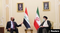 Presiden Irak Barham Salih (kiri) bertemu dengan Presiden Iran yang baru Ebrahim Raisi dalam sebuah pertemuan di Teheran, Iran, pada 5 Agustus 2021. (Foto: The Presidency of the Republic of Iraq Office/Handout via Reuters)