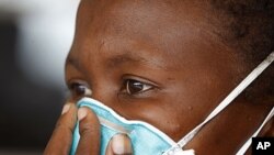 A woman suffering from tuberculosis covers her face at a clinic in the township of Khayelitsha, on the outskirts of Cape Town, South Africa, March 24, 2011