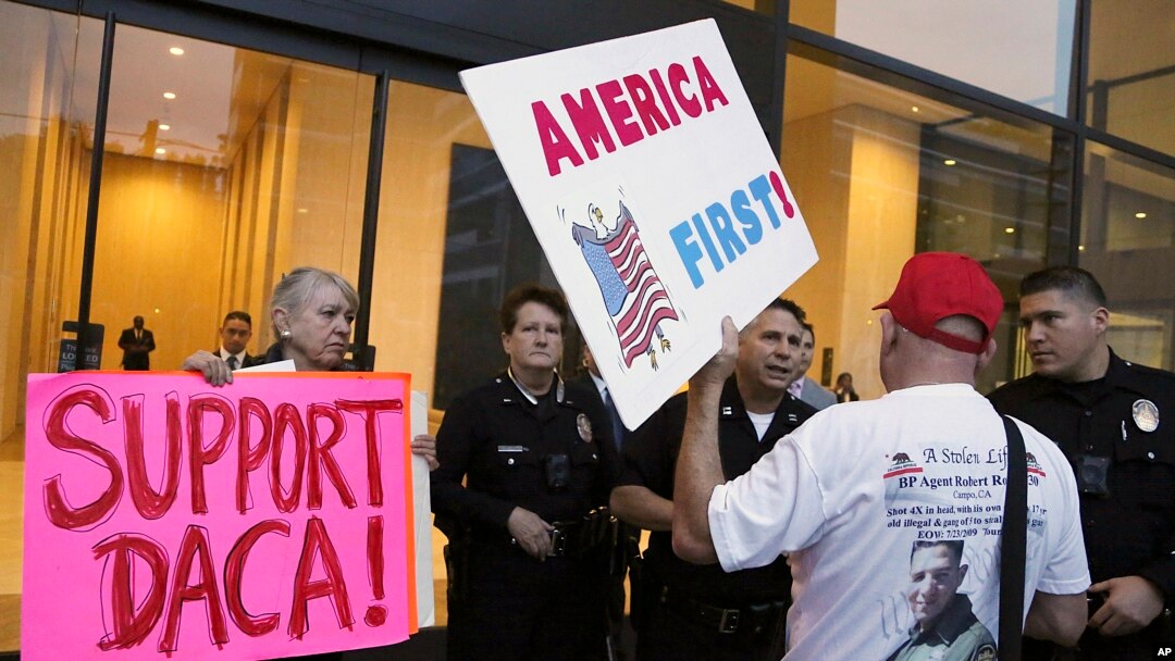 Seorang pendukung Presiden Donald Trump menantang polisi dan seorang pendukung program DACA, saat berlangsungnya aksi demo di luar kantor Senator Demokrat California Dianne Feinstein di Los Angeles, Rabu, 3 Januari 2018. (Foto: dok).