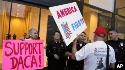 Seorang pendukung Presiden Donald Trump menantang polisi dan seorang pendukung program DACA, saat berlangsungnya aksi demo di luar kantor Senator Demokrat California Dianne Feinstein di Los Angeles, Rabu, 3 Januari 2018. (Foto: dok).