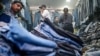 FILE - Customers browse secondhand clothes in a shop at a market in New Delhi, Sept. 28, 2024. 