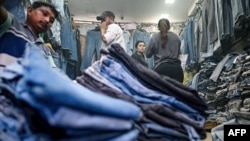 FILE - Customers browse secondhand clothes in a shop at a market in New Delhi, Sept. 28, 2024. 