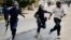 Riot police chase a demonstrator in Bujumbura, Burundi, May 4, 2015.