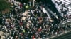 Students and staff gather next to the football field while law enforcement officers respond to a fatal shooting at Apalachee High School in Winder, Georgia, Sept. 4, 2024.