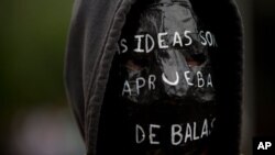 Un manifestante exhibe durante una protesta un cartel en su mochila que dice: “Las ideas son a prueba de bala”.