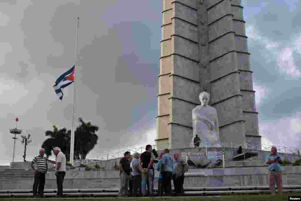 Cuban flag flies at half mast at Revolution Square as people gather following the announcement of the death of Cuban revolutionary leader Fidel Castro, in Havana, Nov. 27, 2016. 