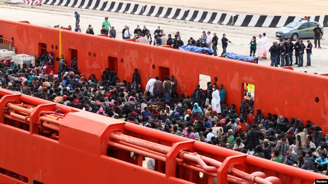 Migrants are seen aboard a navy ship before being disembarked in the Sicilian harbor of Augusta, June 1, 2014.