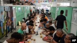 ARCHIVO - Migrantes reciben alimentos en el albergue Oasis de Paz del Espíritu Santo Amparito, en Villahermosa, México, el 7 de junio de 2024. 