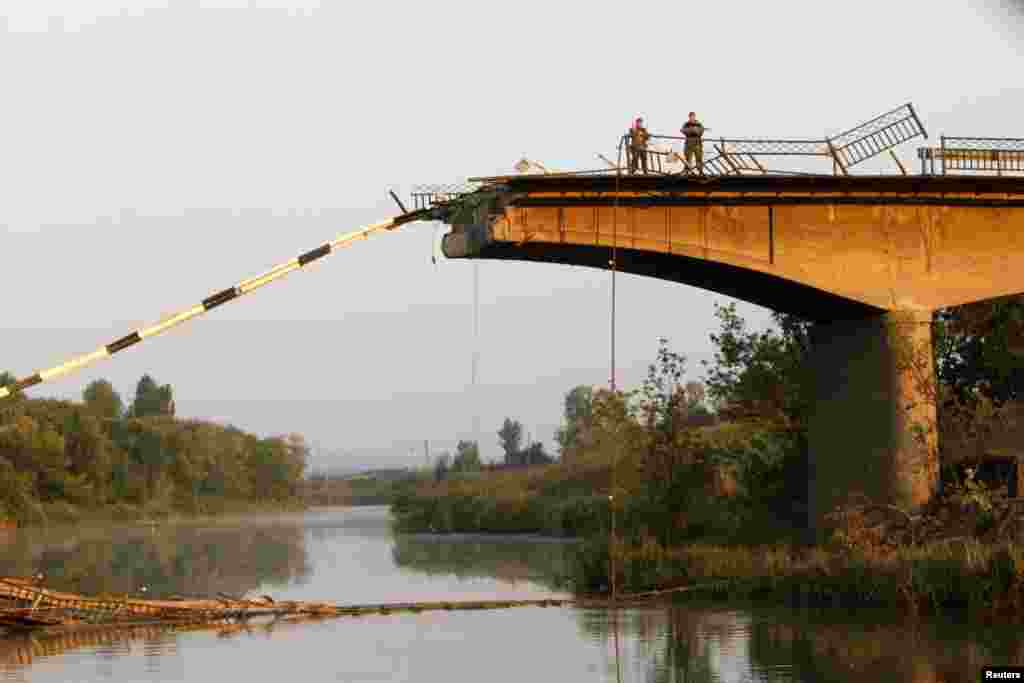 Ukrainian servicemen stand on a bridge that was ruined during battles between the Ukrainian army and pro-Russian separatists on the outskirts of Slovyansk, in the Donetsk region, Aug. 8, 2014.