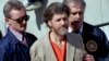 ARCHIVO - Theodore "Ted" Kaczynski está flanqueado por agentes federales mientras lo conducen a un automóvil desde el juzgado federal en Helena, Montana, el 4 de abril de 1996.