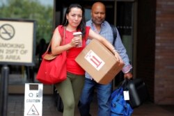 FILE - Two New York Daily News employees leave the newspaper's office after they were laid off, in New York, July 23, 2018.