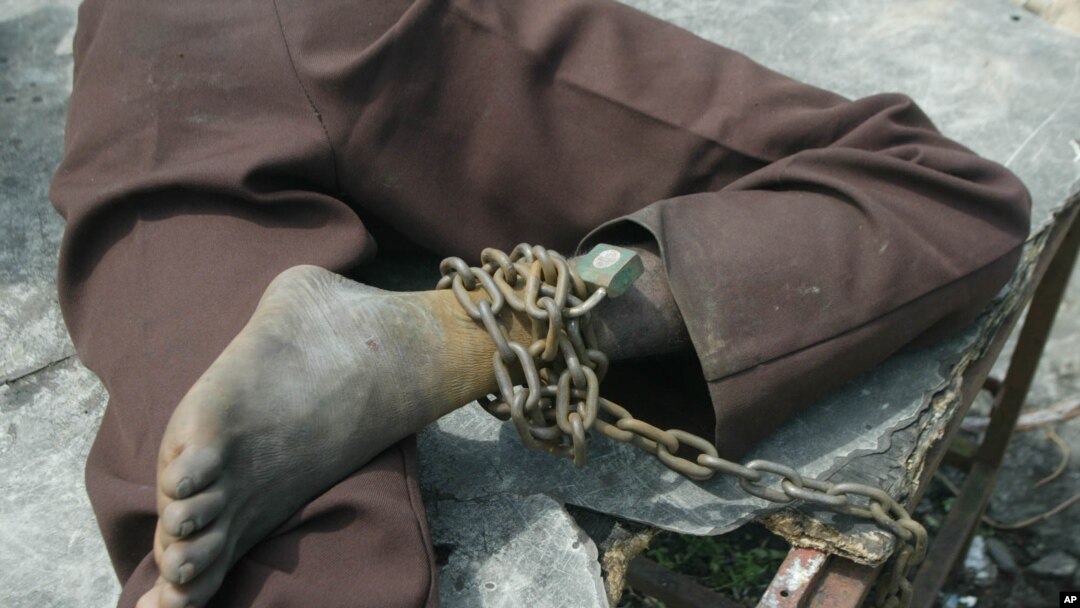 FILE - A patient at a home for the mentally ill is chained to a table in Monrovia, Liberia, Aug. 29, 2003.