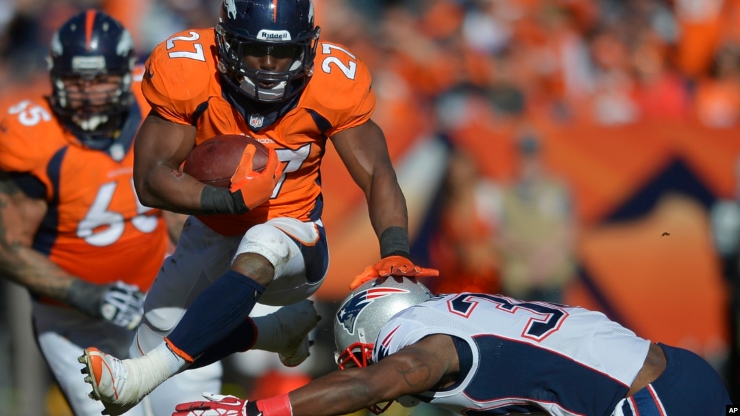 Knowshon Moreno de los Broncos salta sobre Duron Harmon, de los Patriotas, en el juego que definió la Conferencia Americana.