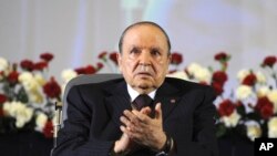 FILE - Algerian President Abdelaziz Bouteflika, sitting in a wheelchair, applauds after taking the oath as president in Algiers, April 28, 2014.