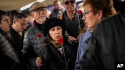 Orang-orang antre untuk meletakkan bunga pada peringatan korban bom kereta api tahun 2004 di dalam stasiun kereta Atocha di Madrid, Spanyol, Senin, 11 Maret 2024. (Foto: AP/Bernat Armangue)