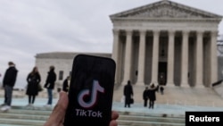 Logoja e platformës TikTok shfaqet në një telefon përpara godinës së Gjykatës së Lartë të Shteteve të Bashkuara