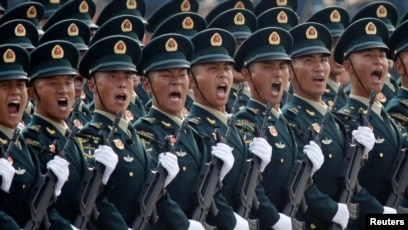 FILE - Soldiers of People's Liberation Army march in formation past Tiananmen Square during the military parade marking the 70th founding anniversary of People's Republic of China, on its National Day in Beijing, Oct. 1, 2019.